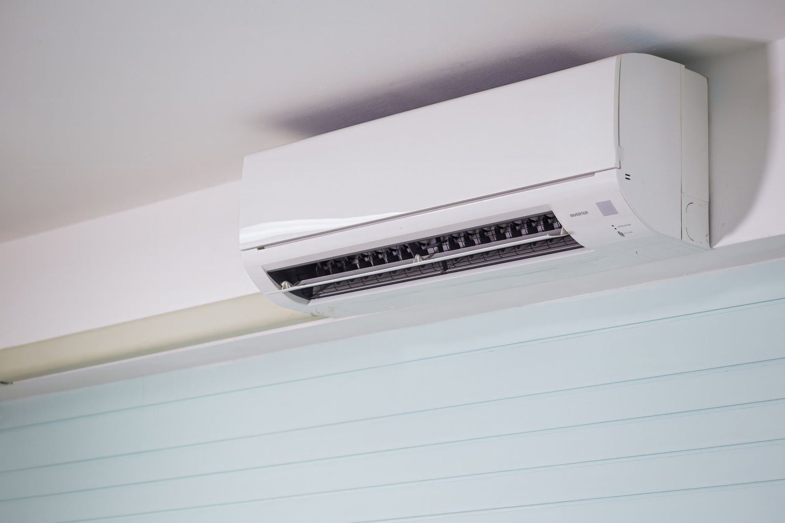 A magnetic remote holder keeps a television remote neatly mounted on a modern wall.